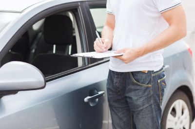 Homme faisant l'état d'une voiture